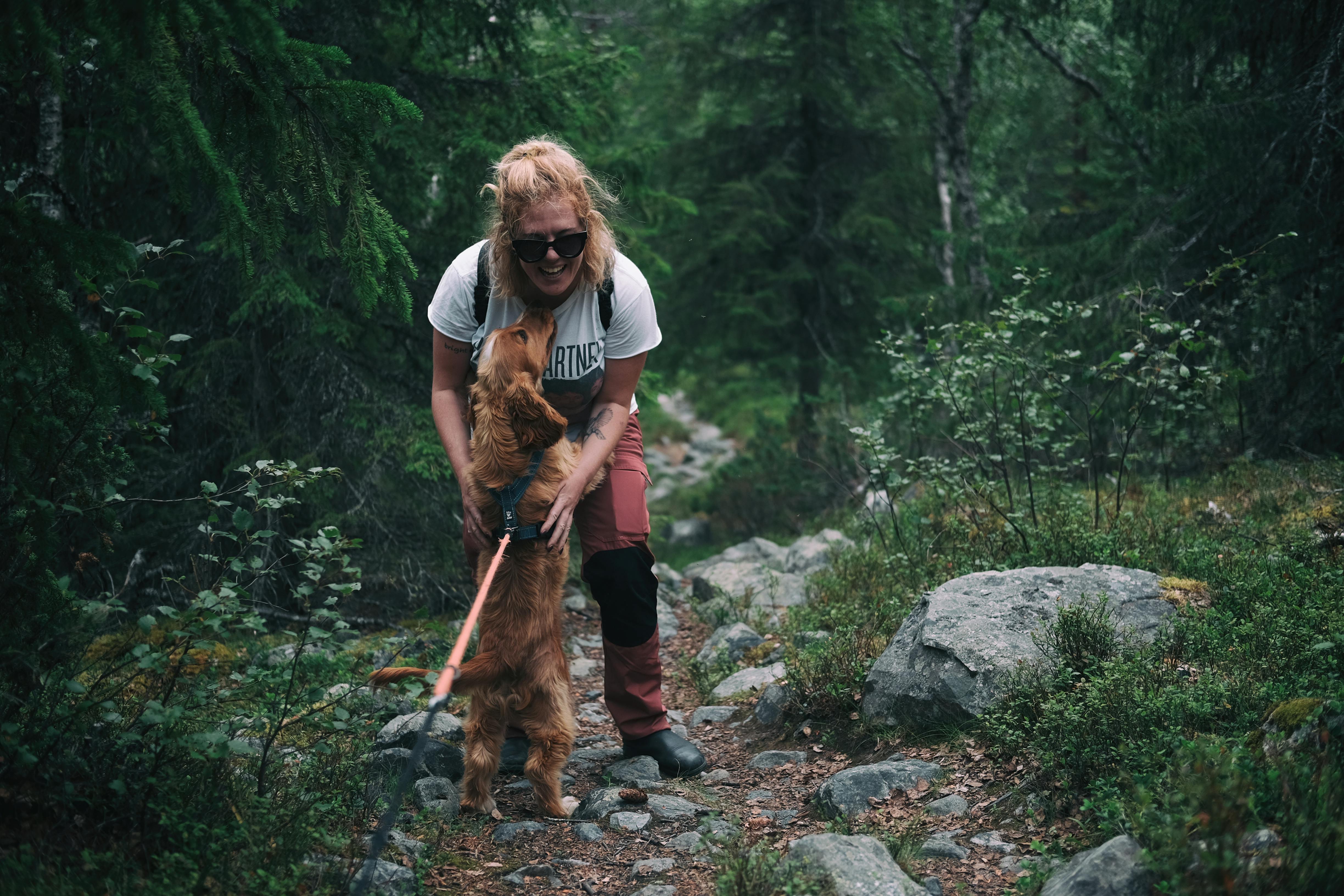 Woman hugging her dog in the woods